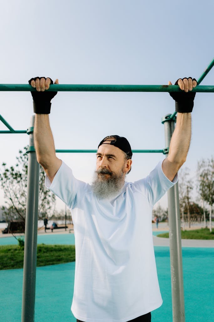 Senior Man in White Shirt Standing and Holding a Pull Up Bar