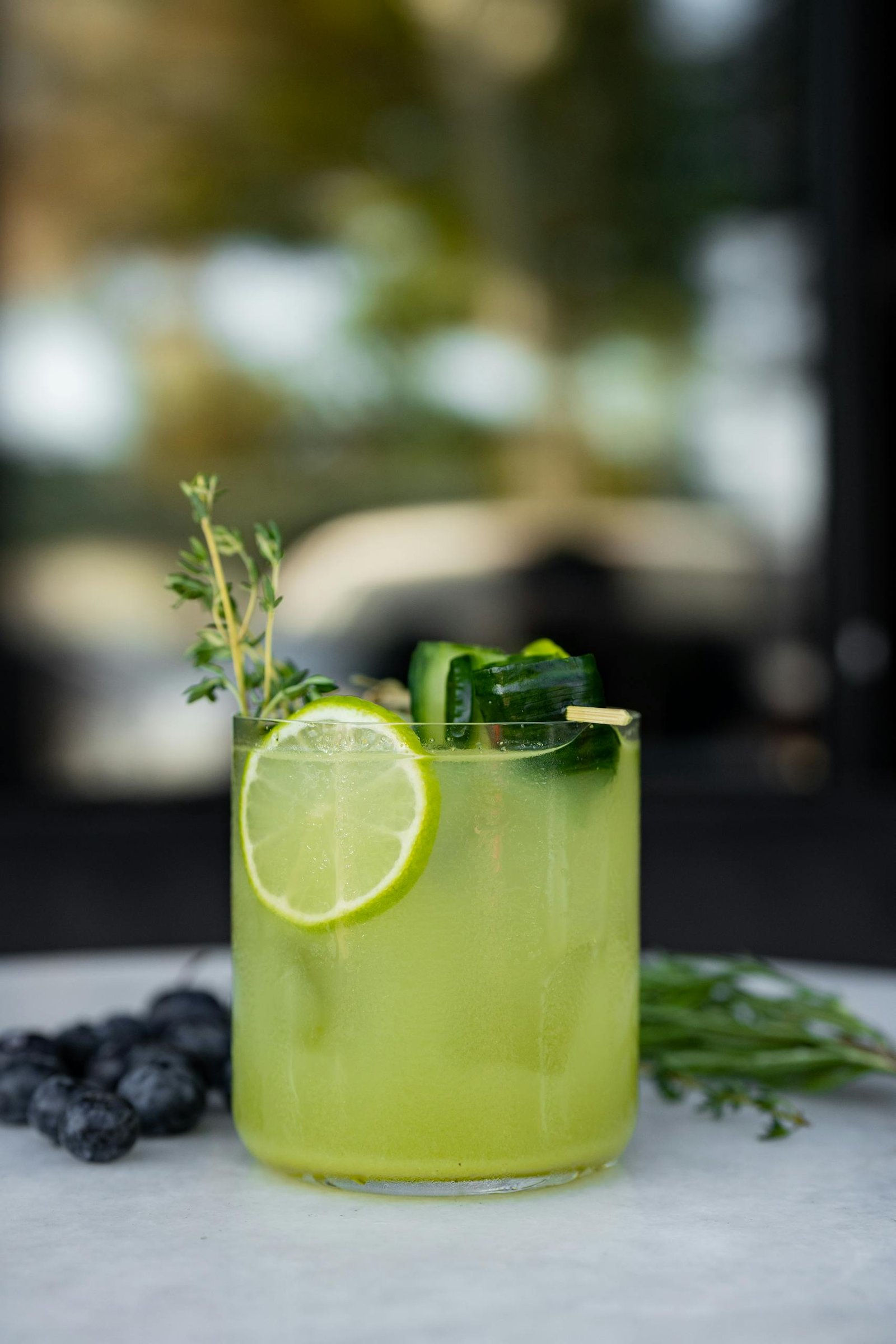 A green drink with cucumber, lemon and blueberries