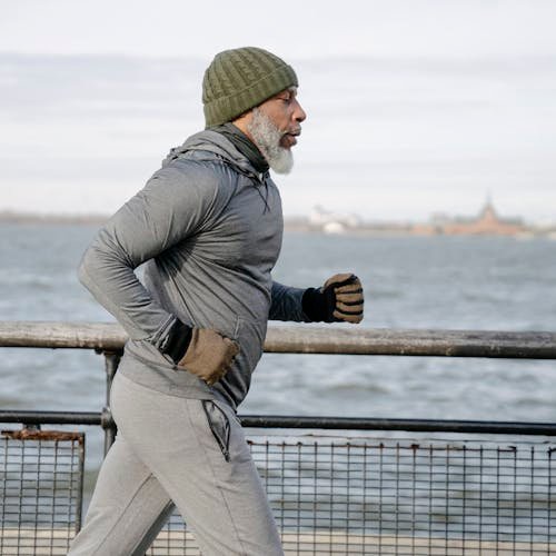 Old black man running near water