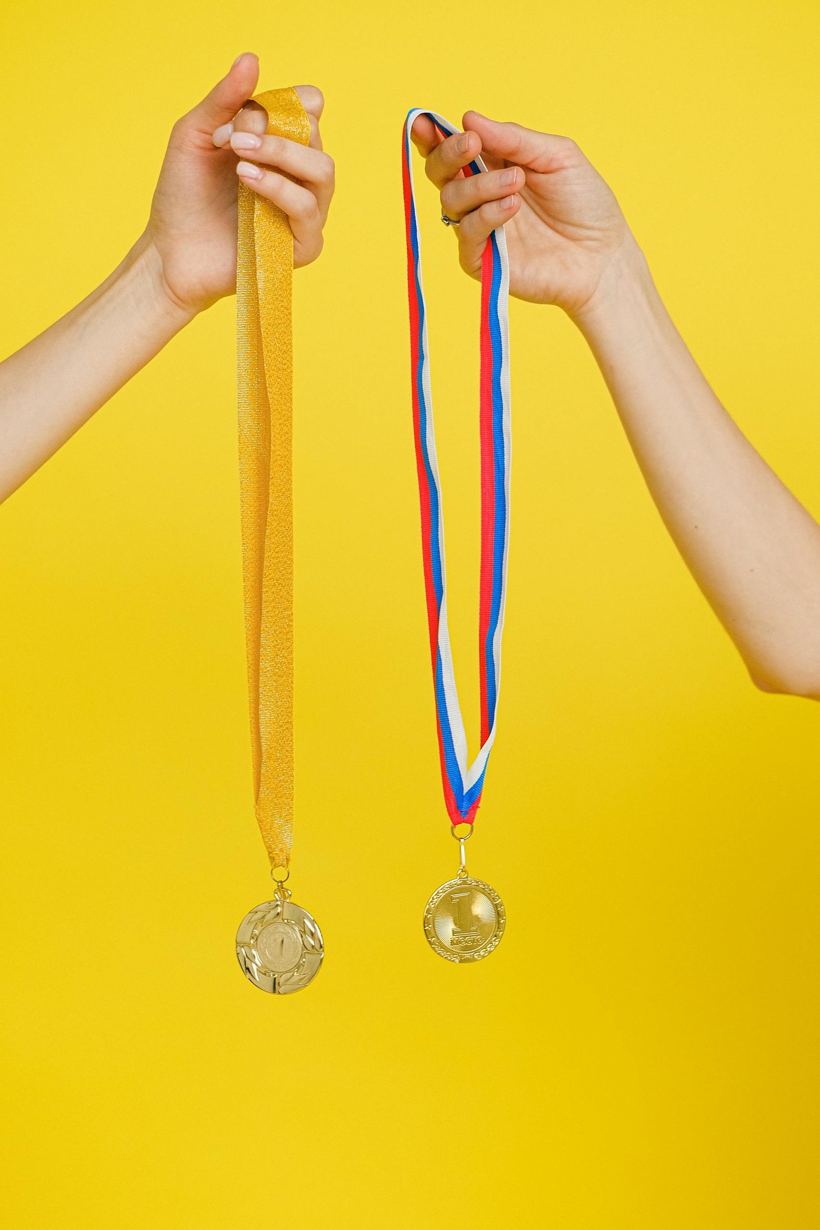 Close-Up Shot of a Person Holding Gold Medals